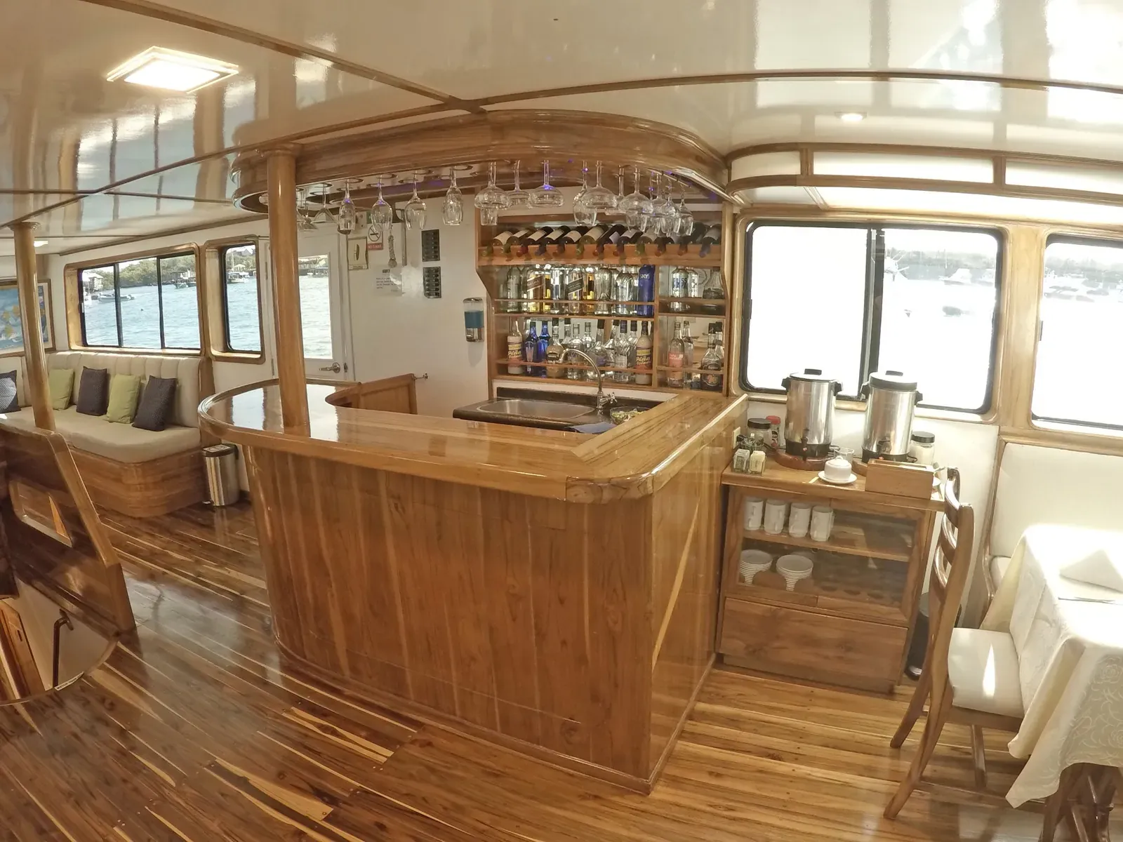 Bar och lounge ombord på Eden i Galapagos med träinredning och panoramafönster.