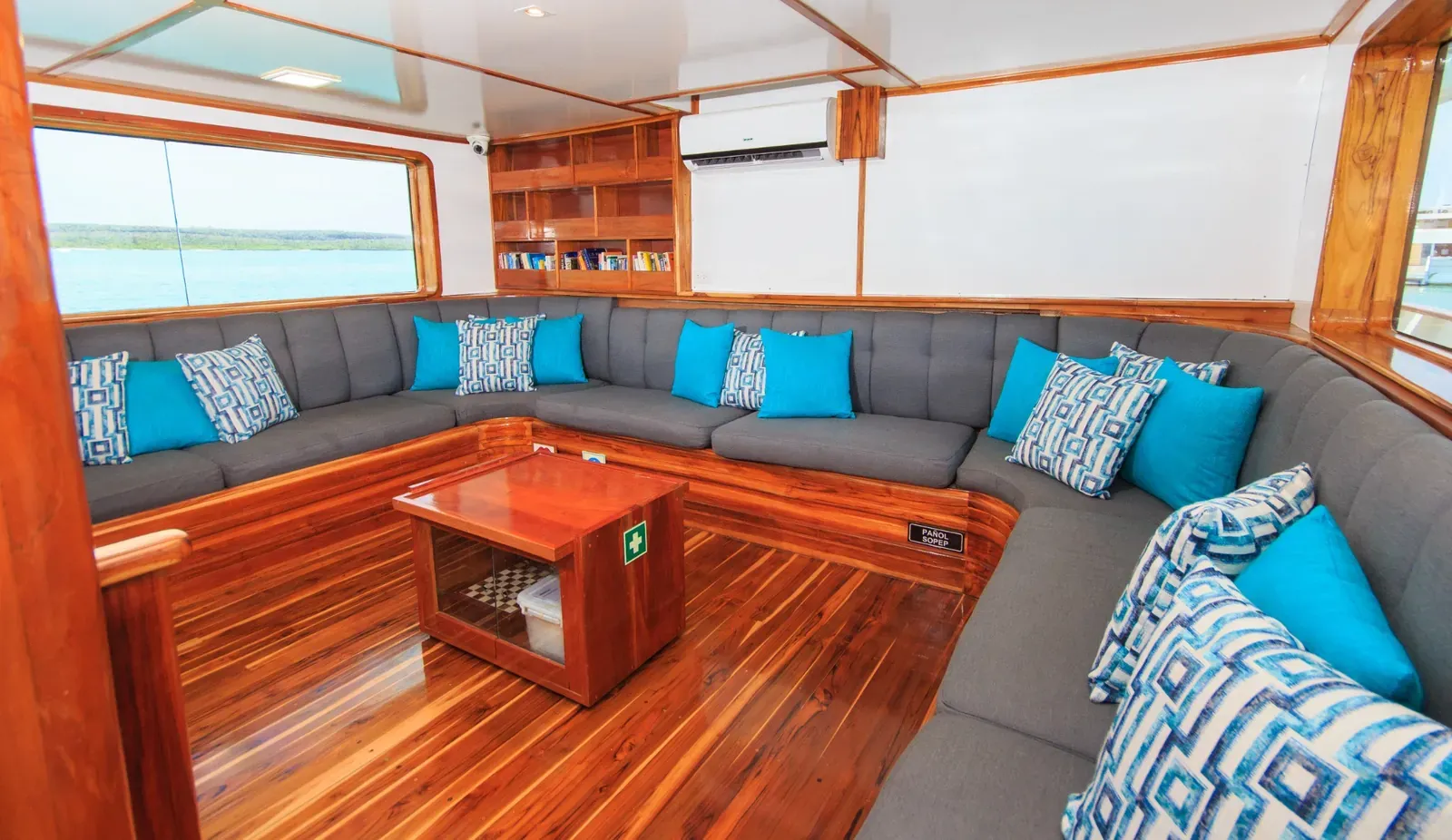 Lounge ombord på Eden i Galapagos med hörnsoffa och blå kuddar.
